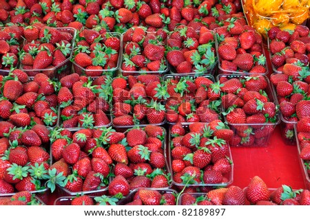 Ripe strawberries in plastic crates at grocery store. Fruit background.