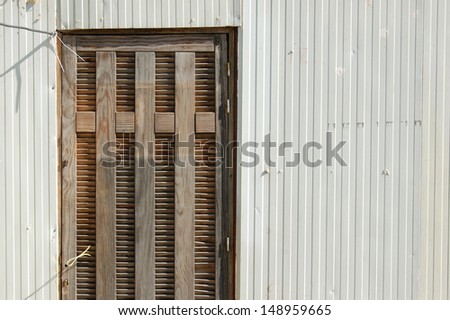 Plastic trailer wall and wooden door exterior abstract background.