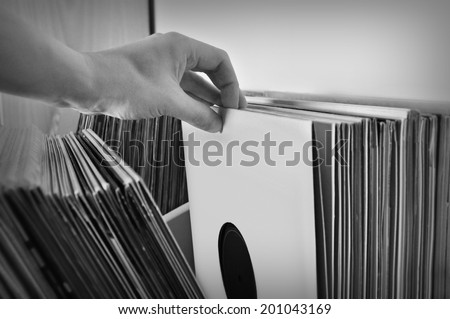 Crate digging through vinyl records music collection. Black and white.