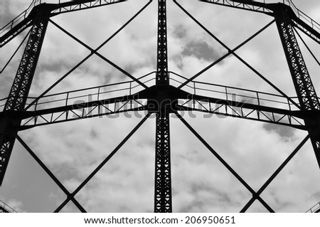 Industrial gasholder frame iron structure exterior abstract architecture. Black and white.