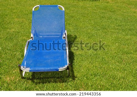 Lawn chair on green grass background. Garden furniture.