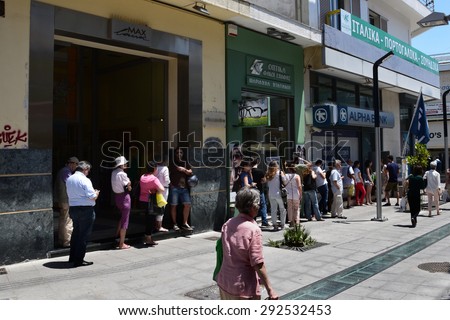 ATHENS, GREECE - JULY 1, 2015: Long queue of people waiting for money at ATM cashpoint. Banks are closed and capital controls allow cash withdrawal of 60 euro per day. Greek financial crisis.
