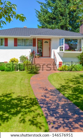 Shadowed pathway at average family house in sunny day.  Usual family house in North America.