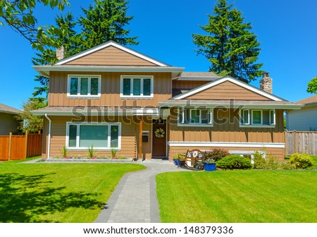 Family house in suburban area of Vancouver, Canada. North American house on blue sky background on a sunny day.