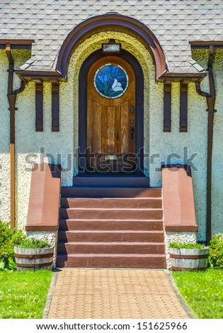Elegant home front door: stylish arch exterior door, wooden door of a house with mosaic glass sections.