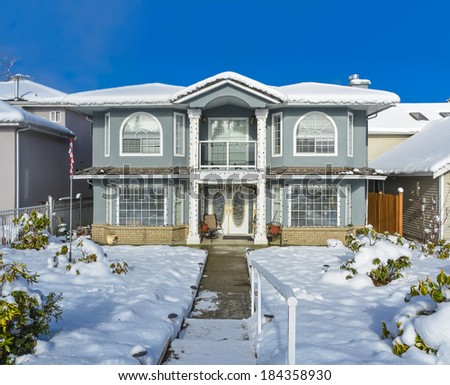 Luxury family house on winter season. Luxury house with handrail on the pathway and blue sky background