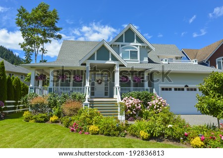 Residential house with patio and garage on blue sky background. Family house in British Columbia, Canada.
