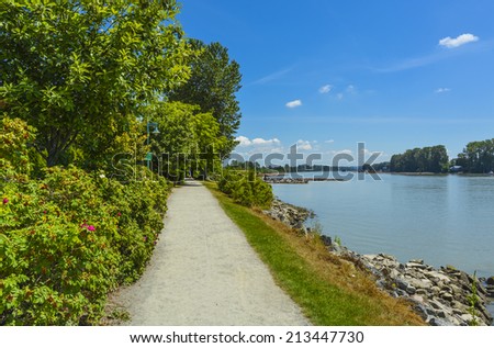 Walk way on river side close to the water. Fraser river side path in Vancouver, British Columbia. Peace of mind view.