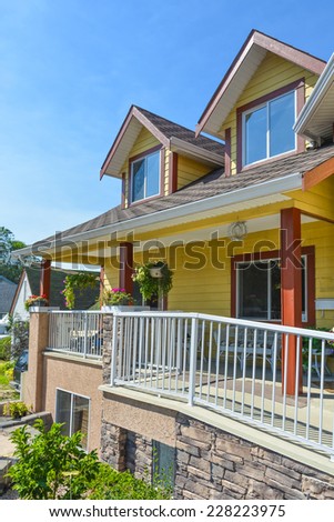 Fragment of luxury residential house with patio in front and blue sky background, Canada.