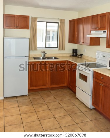 Kitchen with wooden cabinets, fridge, and electric stove