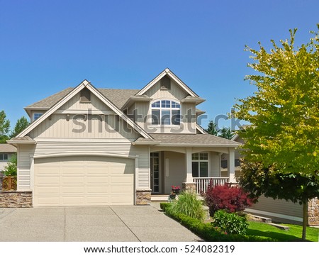 Average family house with concrete driveway to the garage on blue sky background