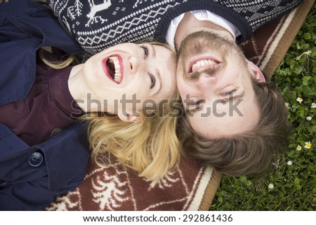 Couple laughing, looking to the sky. Shoot from above.