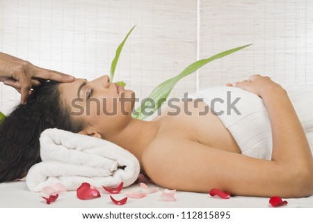 Young woman getting head massage from a massage therapist