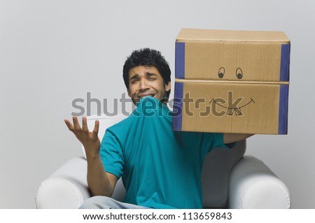 Man holding a cardboard box and looking sad