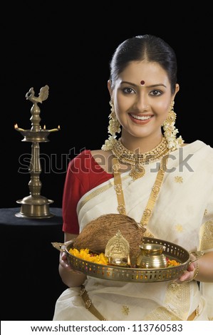 Portrait of a South Indian woman holding a plate of religious offerings