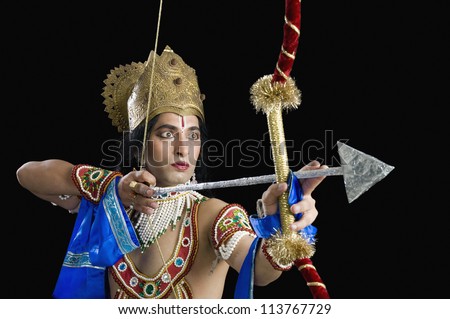 Stage artist dressed-up as Rama and holding a bow and arrow