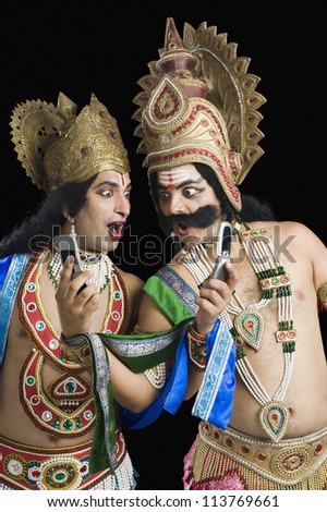 Two actors dressed-up as Rama and Ravana and reading text message