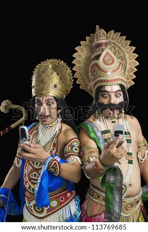 Two actors dressed-up as Rama and Ravana and reading text message