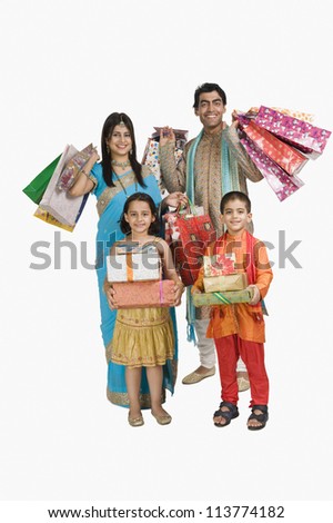 Family carrying shopping bags and gifts for Diwali