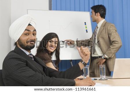 Businessman pointing on a flip chart in a conference room