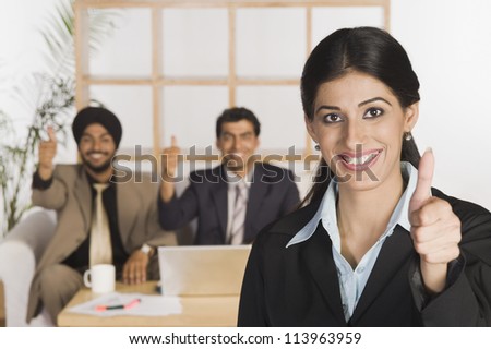 Business executives showing thumbs up sign