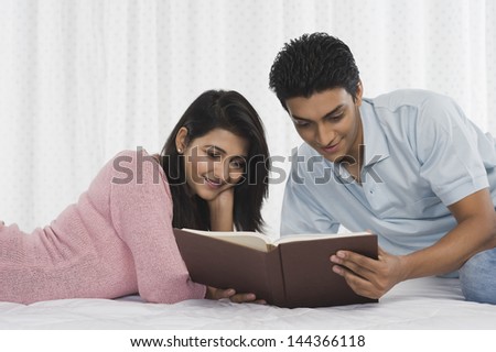 Couple reading a book on the bed