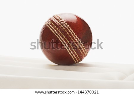 Close-up of a cricket ball on a cricket pad