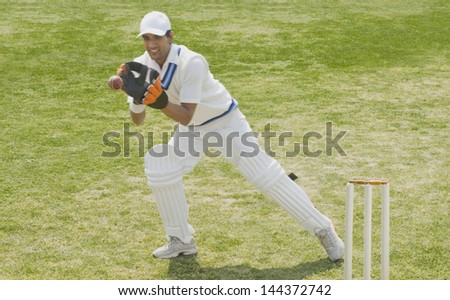 Cricket wicketkeeper catching a ball behind stumps