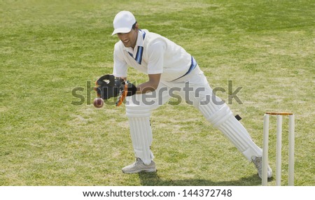 Cricket wicketkeeper catching a ball behind stumps