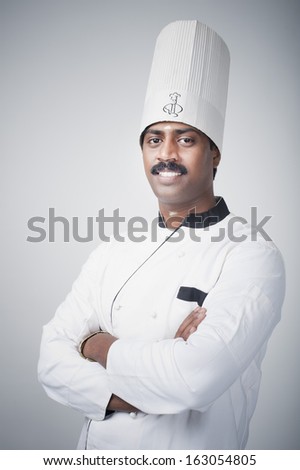 South Indian chef standing with his arms crossed and smiling
