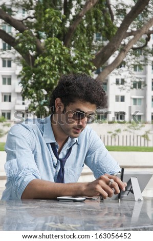 Businessman using a digital tablet in a garden