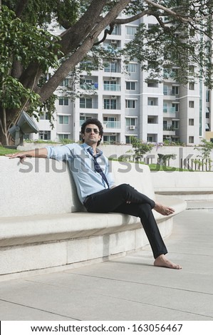 Businessman sitting on a bench at a garden