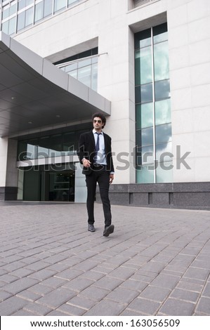 Businessman walking in front of an office building