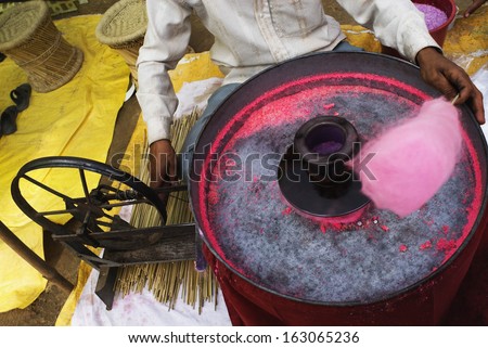 Vendor making pink cotton candy on his machine