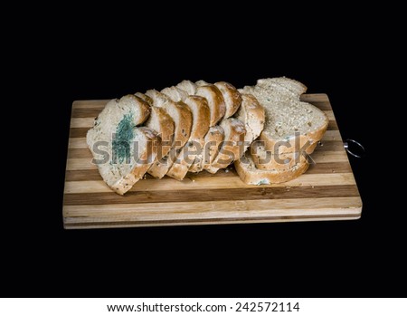 Mold fungus on slices of bread on a chop plate board isolated on black  background
