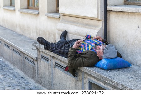 BUCHAREST, ROMANIA - APRIL 25, 2015: Drunk man sleeping on street in full daylight