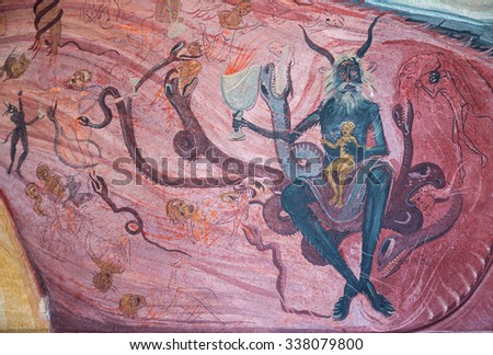 TISMANA, ROMANIA - CIRCA JUNE, 2013: Devils and bottom of hell depiction in the fresco on the walls of Tismana Monastery, 14th century old. Human suffering eternal damnation in flames of hell.
