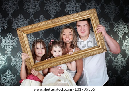 Smiling family looking through an empty frame