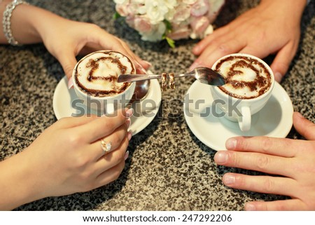Two cups of coffee and wedding rings