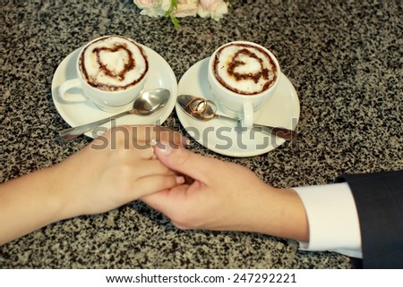 Two cups of coffee and wedding rings