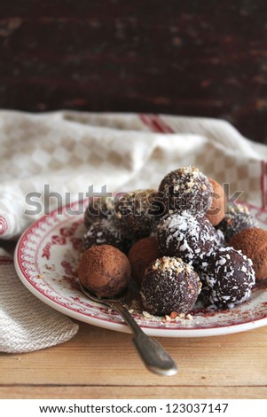 Chocolate truffles with cocoa powder, coconut and chopped nuts on plate
