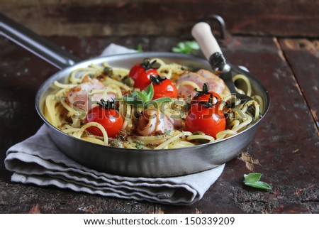 Cooked spaghetti pasta with courgette or zucchini and tomatoes in a bowl ready to serve
