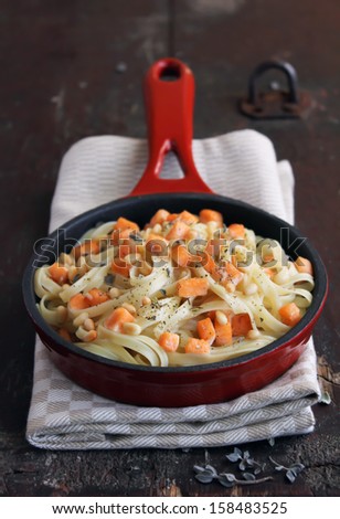 Whole wheat pasta with roasted salmon and cream sauce in a pan
