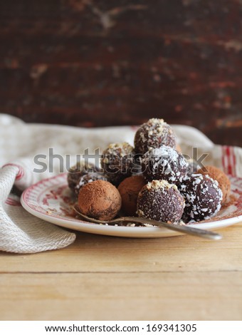 Sweet chocolate truffles with cocoa powder, chopped nuts and coconut on a dessert plate perfect for celebrations as Valentine Day, Easter, Mother Day, Birthday