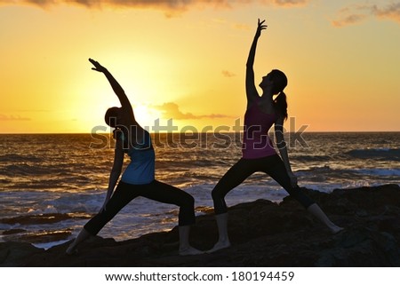 Teacher and student doing yoga at Sunrise, at Coollum Beach, QLD., Australia.