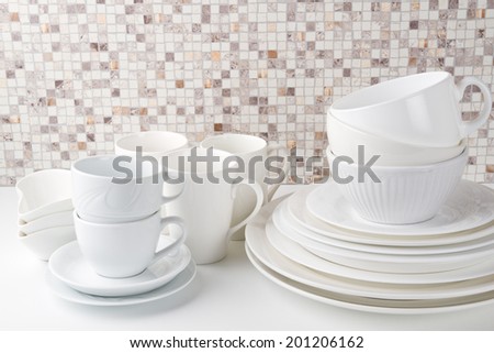 Set of white dishes on white kitchen table