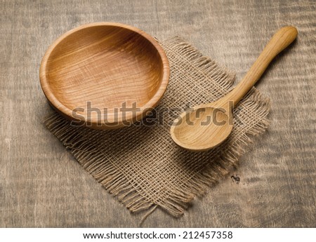 Wooden bowl and wooden spoon on rustic wooden table