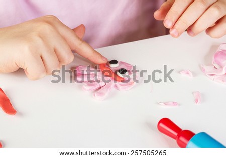 Child hands playing with colorful clay