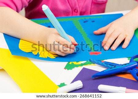 Child makes application of colored paper