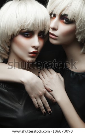 Portrait of beautiful girls twins with clean skin and bright makeup
